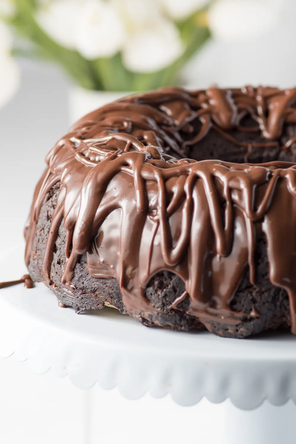 Dark chocolate ganache dripping from a chocolate bundt cake