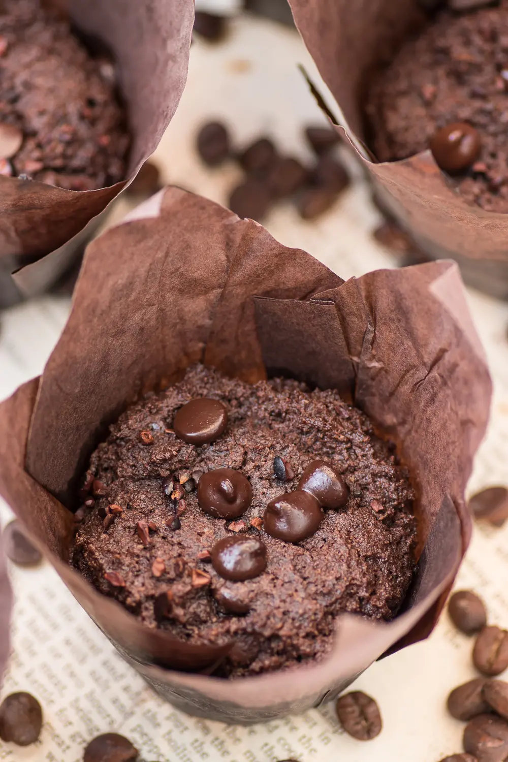Triple chocolate muffins in brown muffin wrappers on a white background 