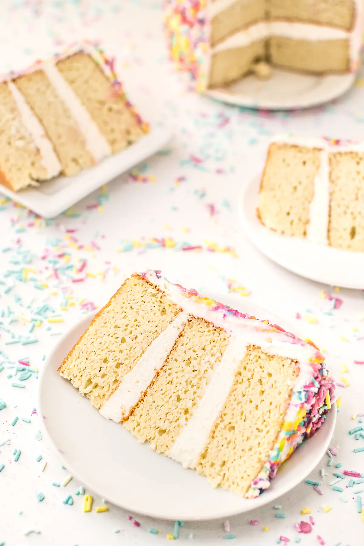 Slices of low carb birthday cake with white icing surrounded by sprinkles 