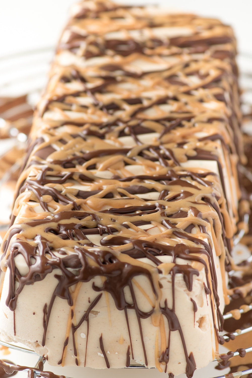 chocolate and peanut butter drizzle over a cold ice cream cake