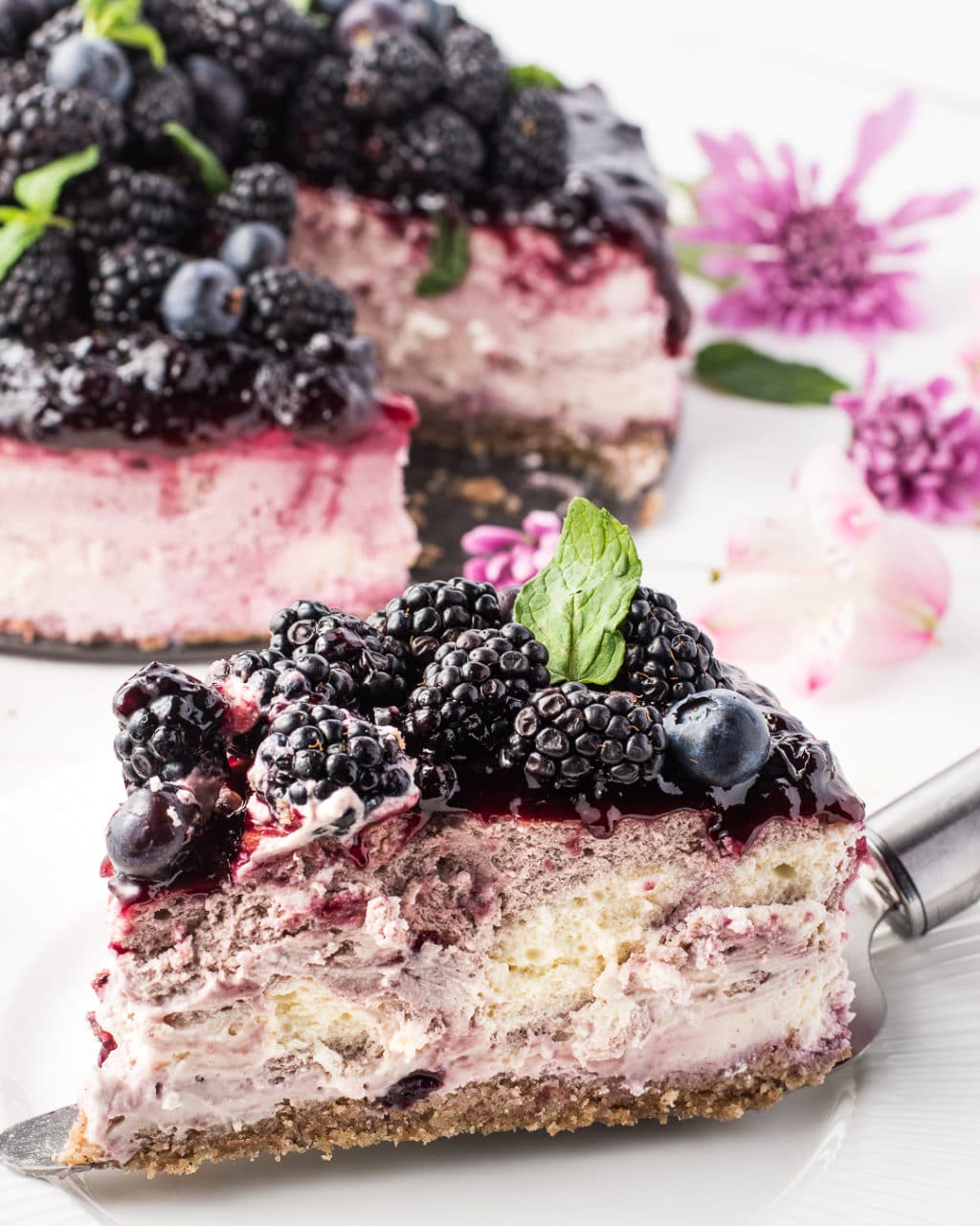 A piece of blackberry cheesecake on a cake server