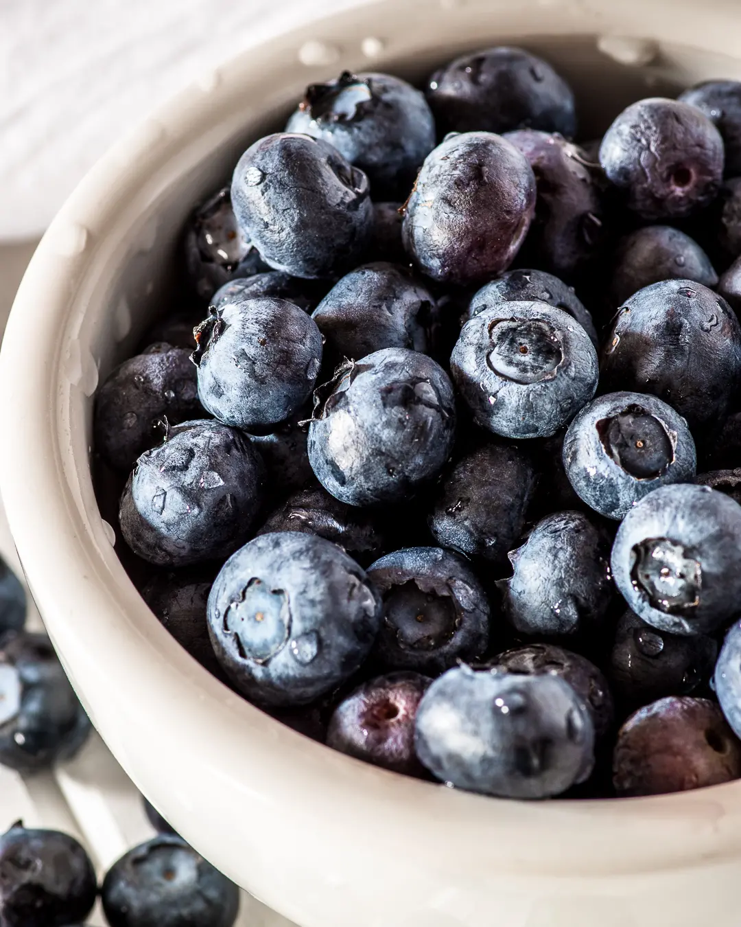 a white bowl filled with fresh blueberries 