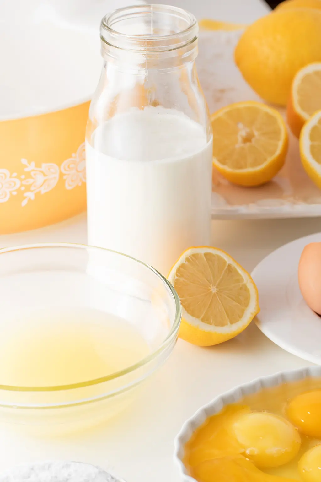 lemons, cream, egg whites and egg yolks on a white background