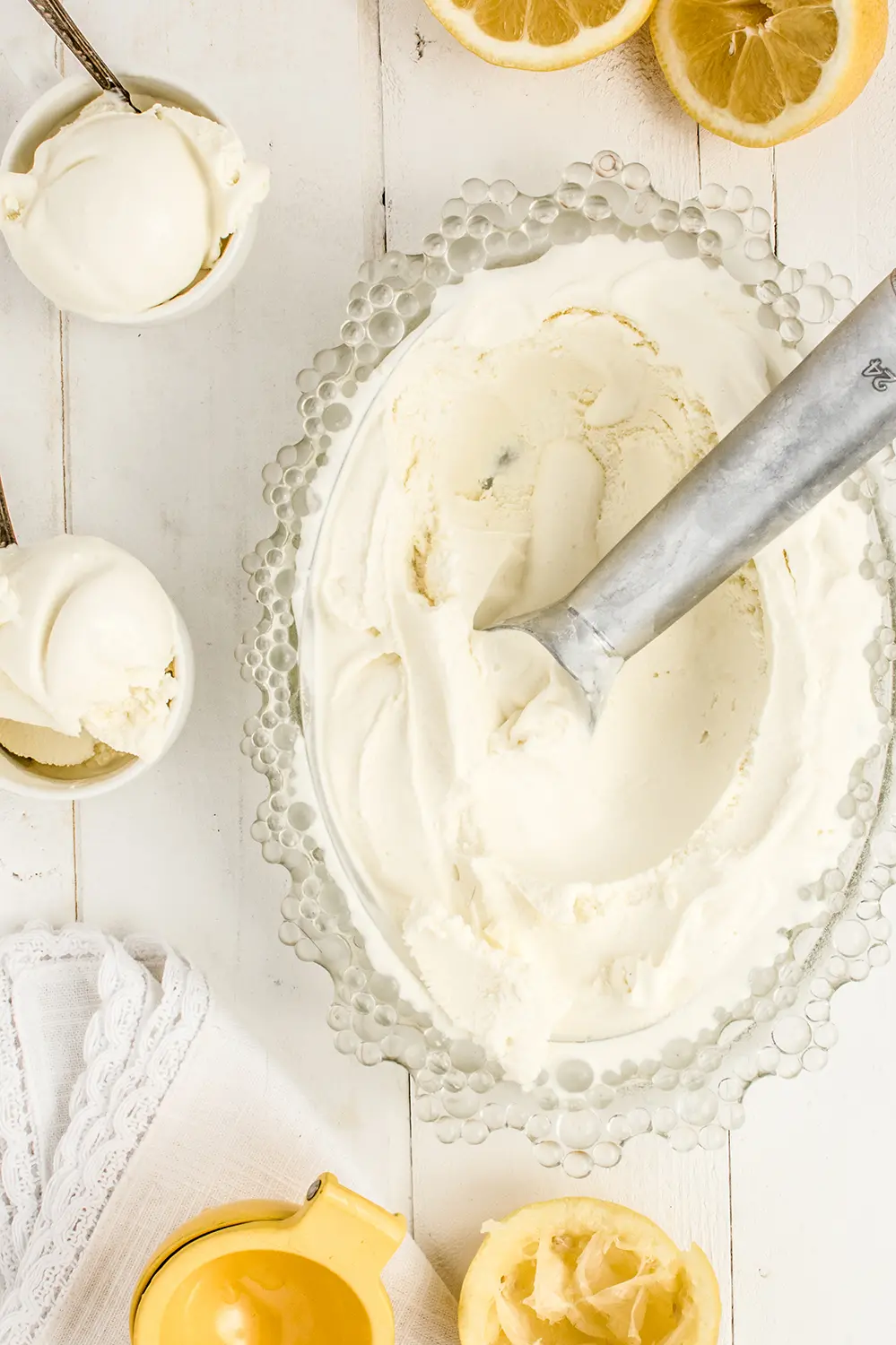 a bowl of frozen lemon gelato with small bowls and bright yellow lemons