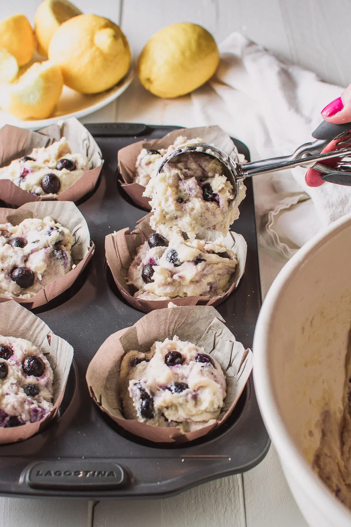 Low carb blueberry muffin batter being scooped into muffin tins