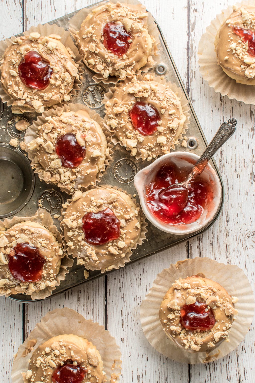 PB&J muffins in a vintage muffin tin with a small bowl of strawberry jam