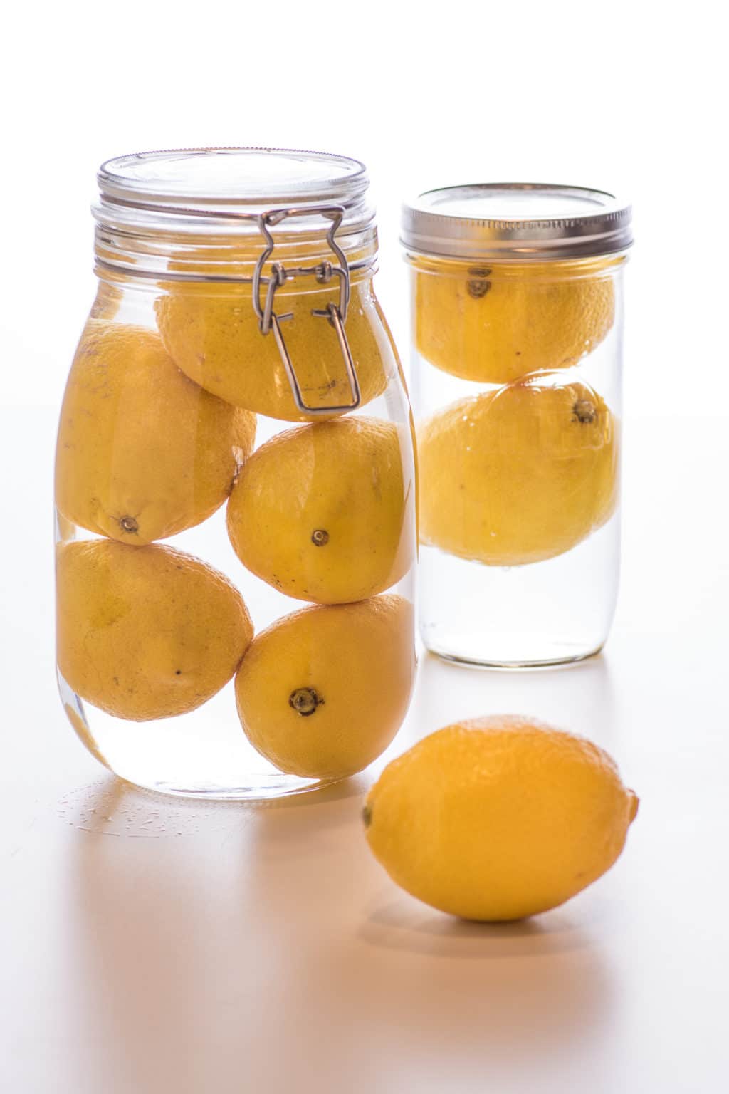 Fresh lemons stored in glass jars filled with water. 