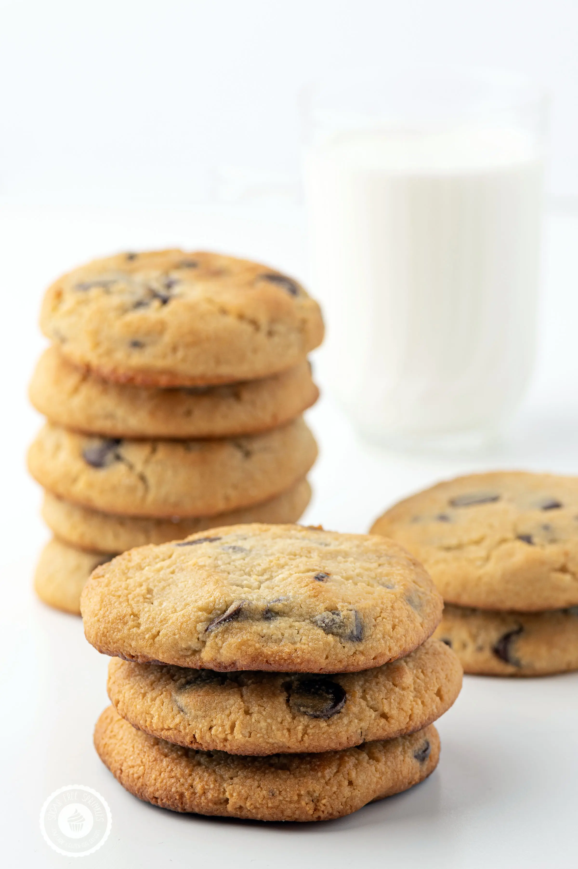 Stacks of keto chocolate chip cookies with a glass of milk.