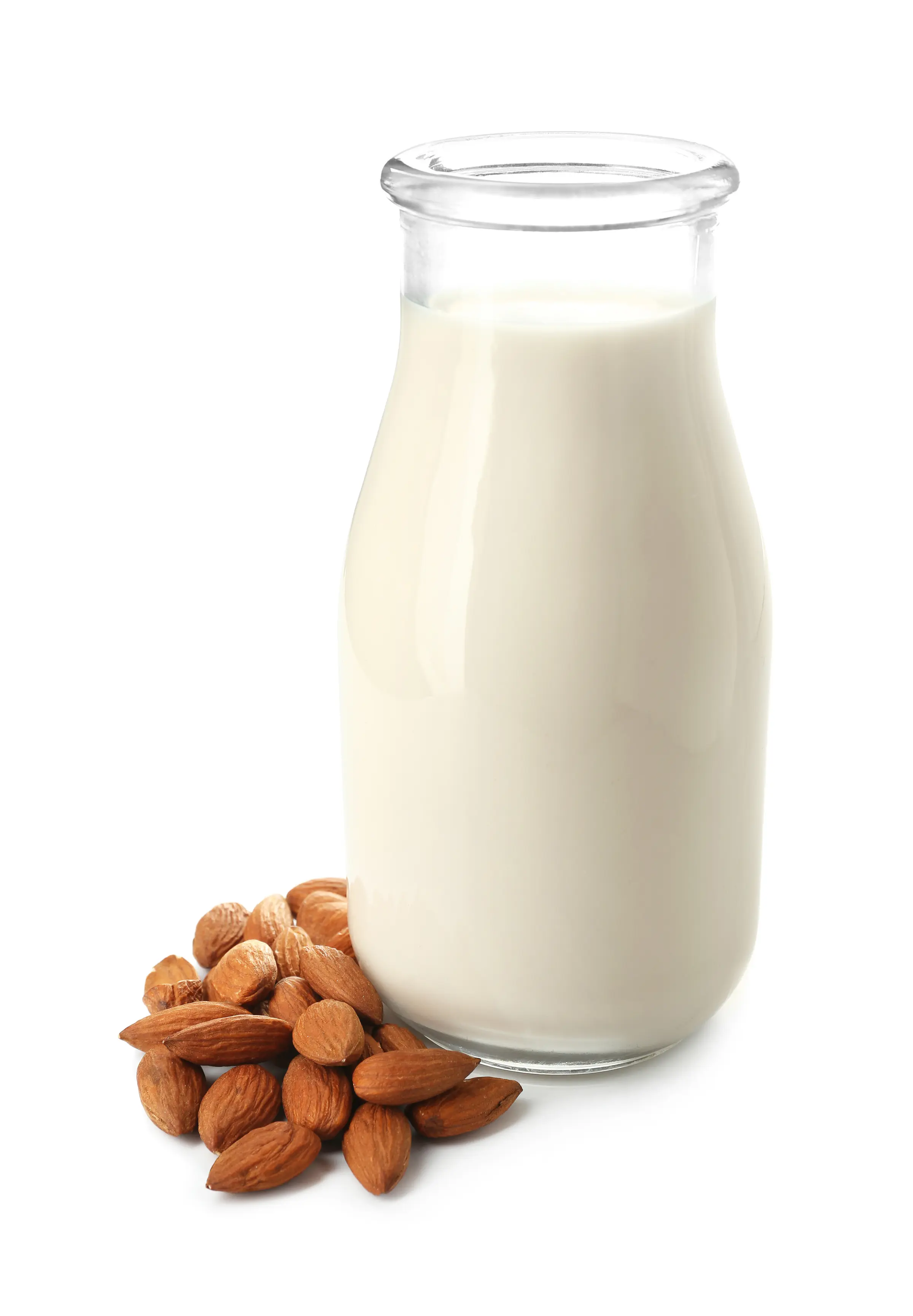 A tall glass bottle of almond milk, with a small pile of almonds beside it.