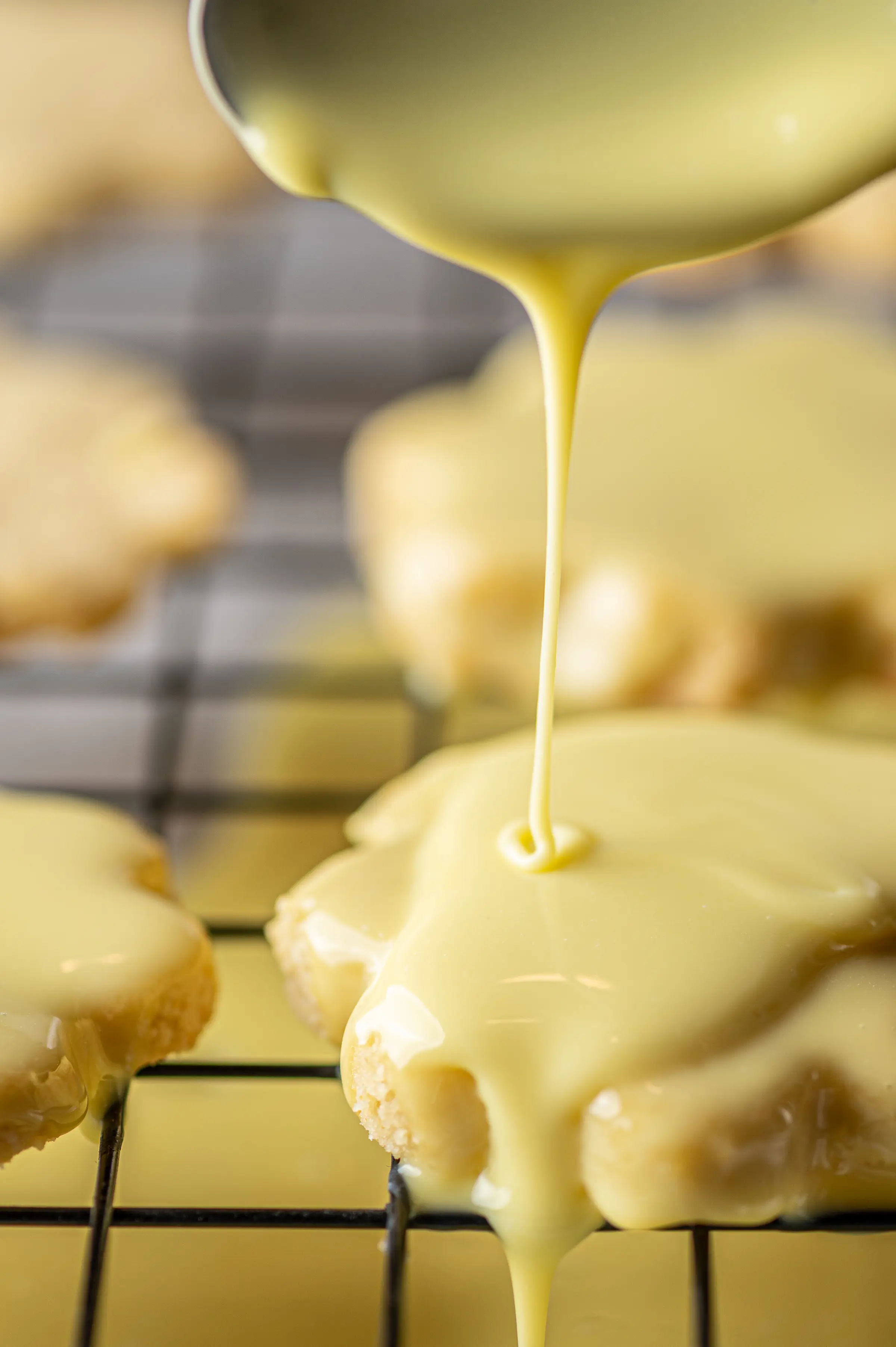 White chocolate lemon drizzle dripping over the edge of a keto lemon cookie. 