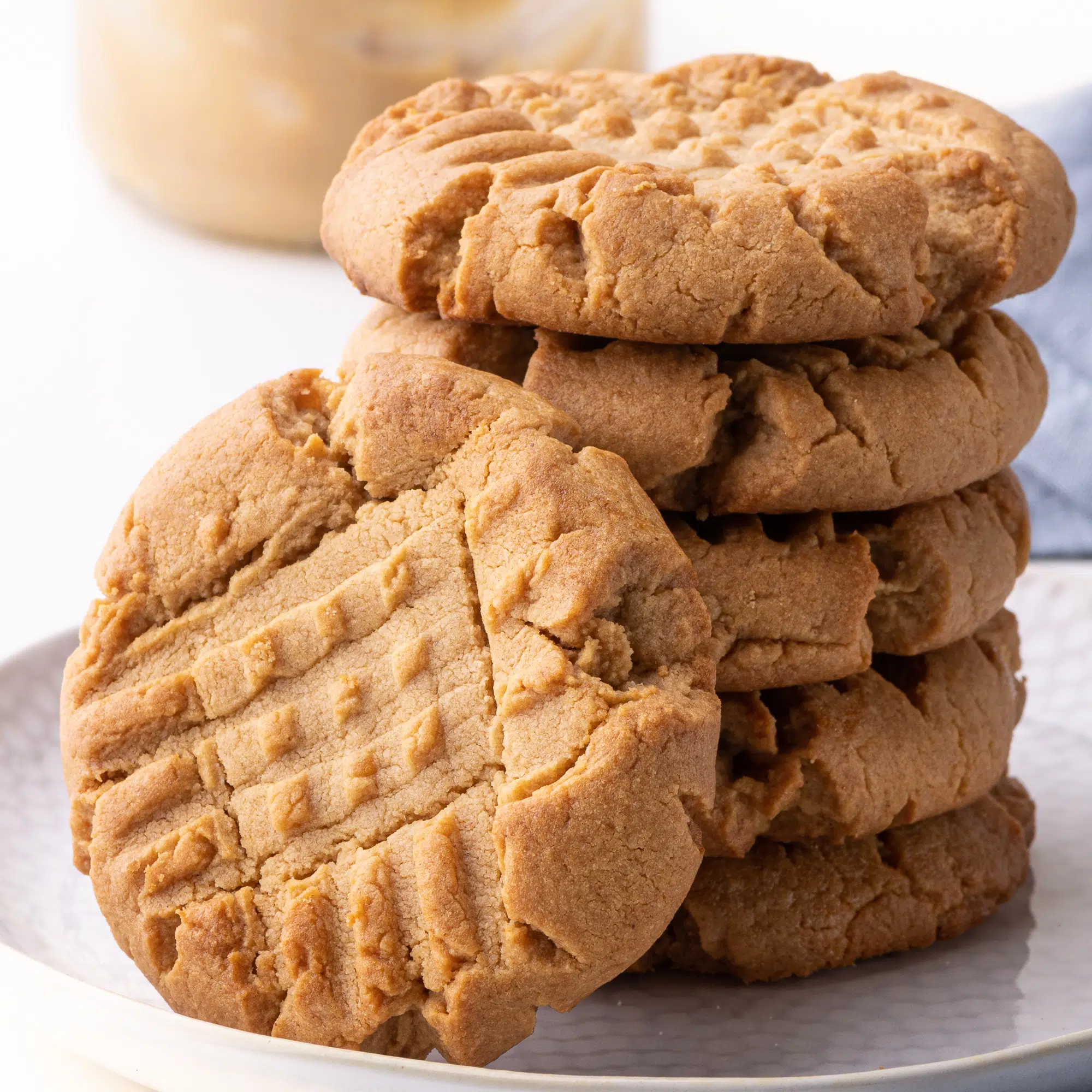 A stack of peanut butter keto cookies against a bright white background. 