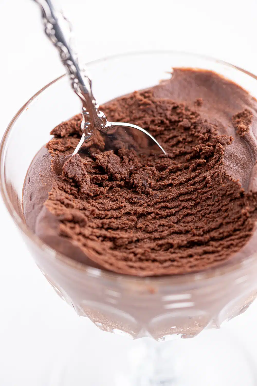 A dish of dark chocolate low carb mousse with a scoop removed to show the interior texture. 